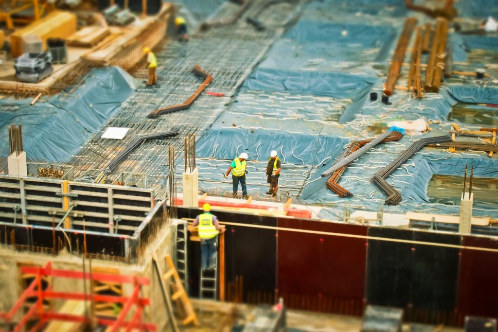 man-in-yellow-safety-vest-climbing-on-ladder-159358 High-angle view of construction workers on a building site, engaging in construction work.